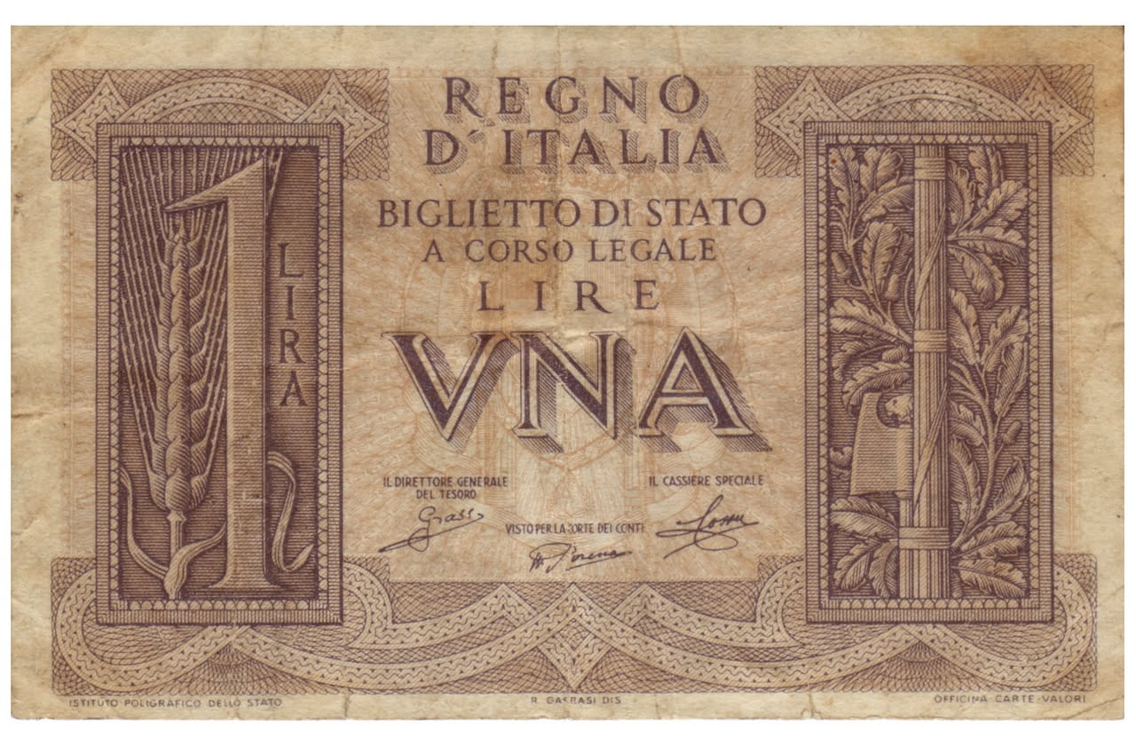 Libretto di risparmio cartaceo degli anni Settanta con copertina rossa, pagine ingiallite e annotazioni manoscritte di depositi e prelievi, poggiato su una scrivania in legno accanto a una penna