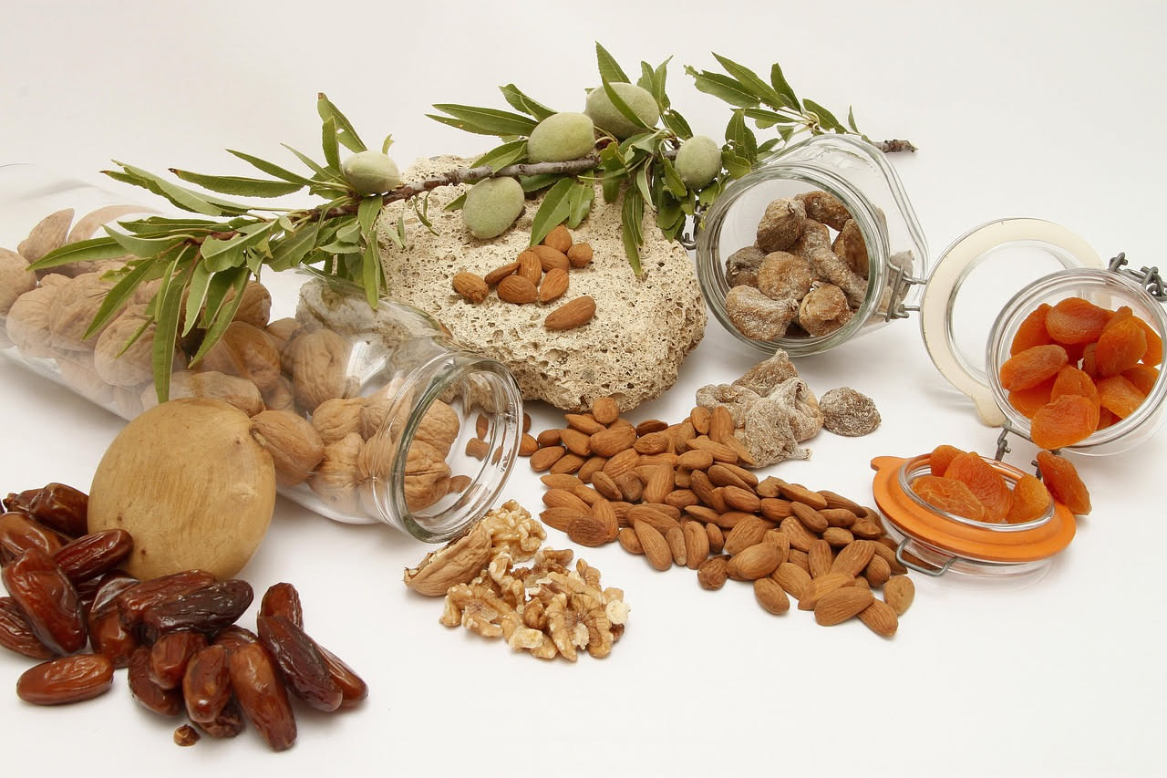 Una manciata di frutta secca mista con noci, mandorle, nocciole e pistacchio su uno sfondo di legno naturale