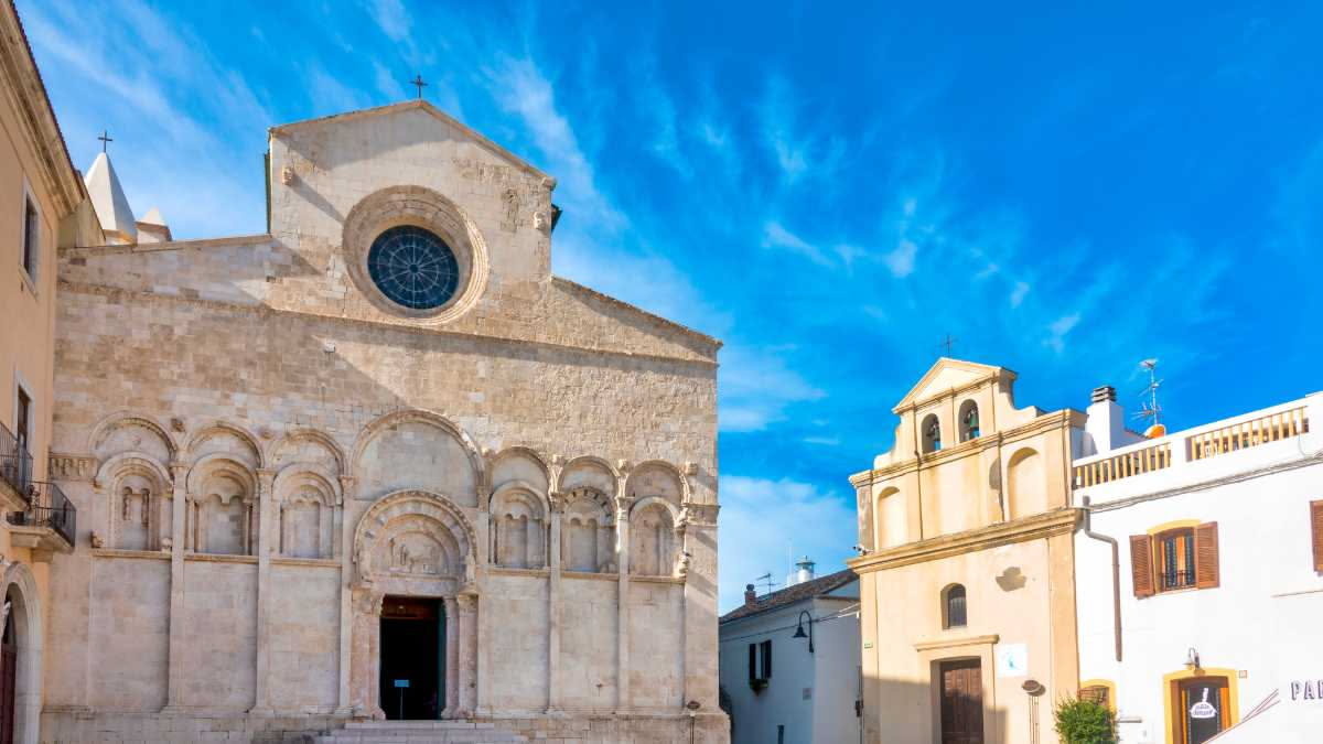 Vista aerea del borgo di Atri con la cattedrale di Santa Maria Assunta al centro, circondato da case in pietra e dalla valle verde del Vomano in Abruzzo